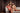 Group of 3 women wearing red, black and nude lingerie bra and brief sets sitting on a sofa indoors