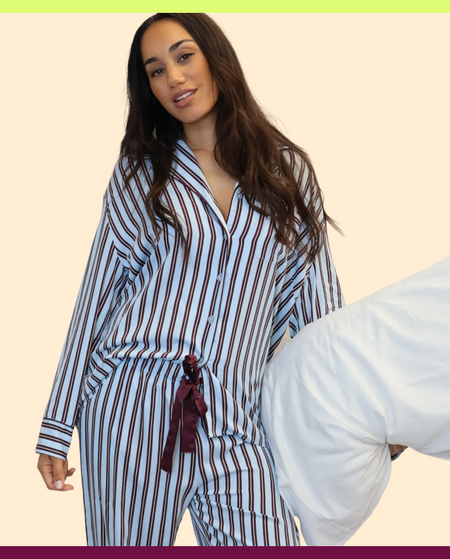 Woman wearing a striped pajama set with a plain background