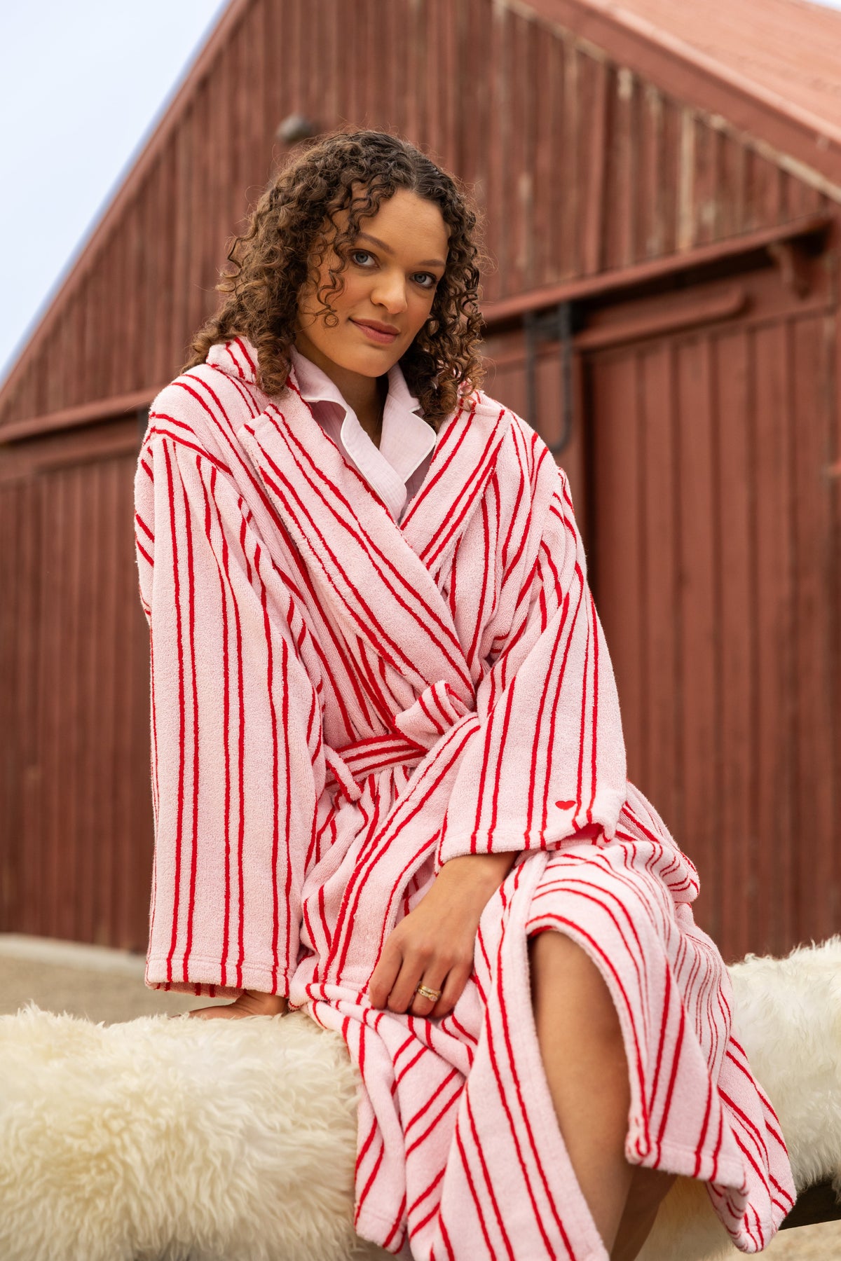 model poses in pink and red stripe robe