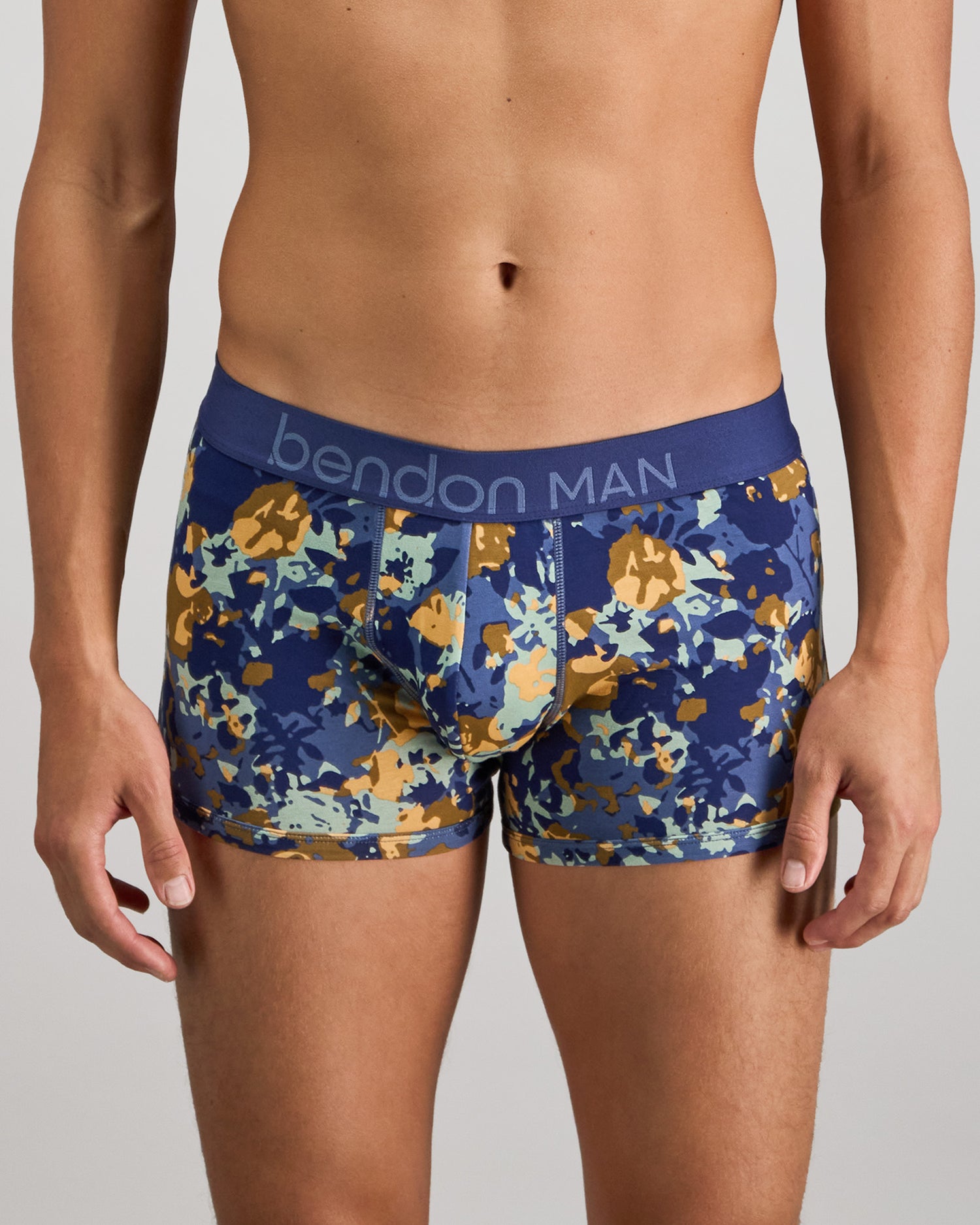 Model wears Retros Print Mens Trunk in WILD CAMO PRINT. On body front view