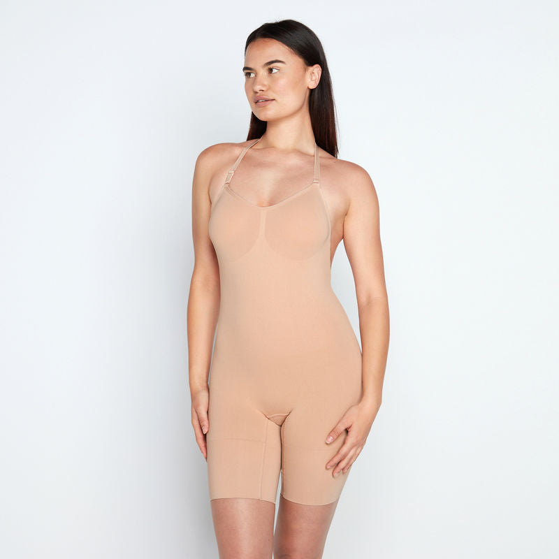 Model wears Medium Control Jumpsuit in CARAMEL. On body front view