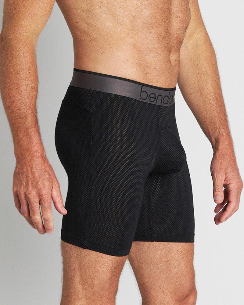 Model wears Everyday Active Mens Long Trunk in BLACK. On body side view
