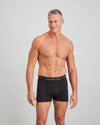 Model wears Cotton Classics Mens Trunk in BLACK. On body front view