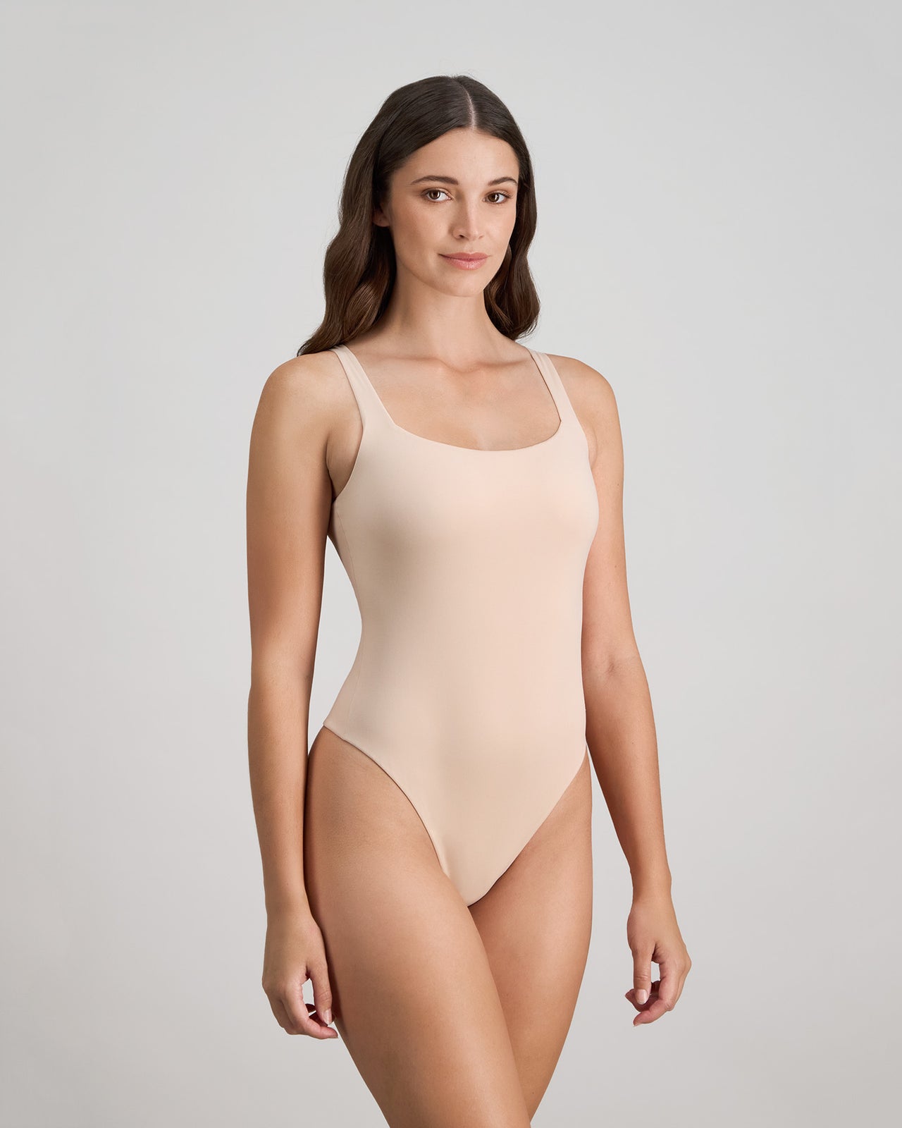 Model wears Extra-Ordinary Bodysuit in LATTE. On body side view