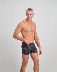 Model wears Cotton Stretch Mens Trunk in NAVY/WHITE. On body side view