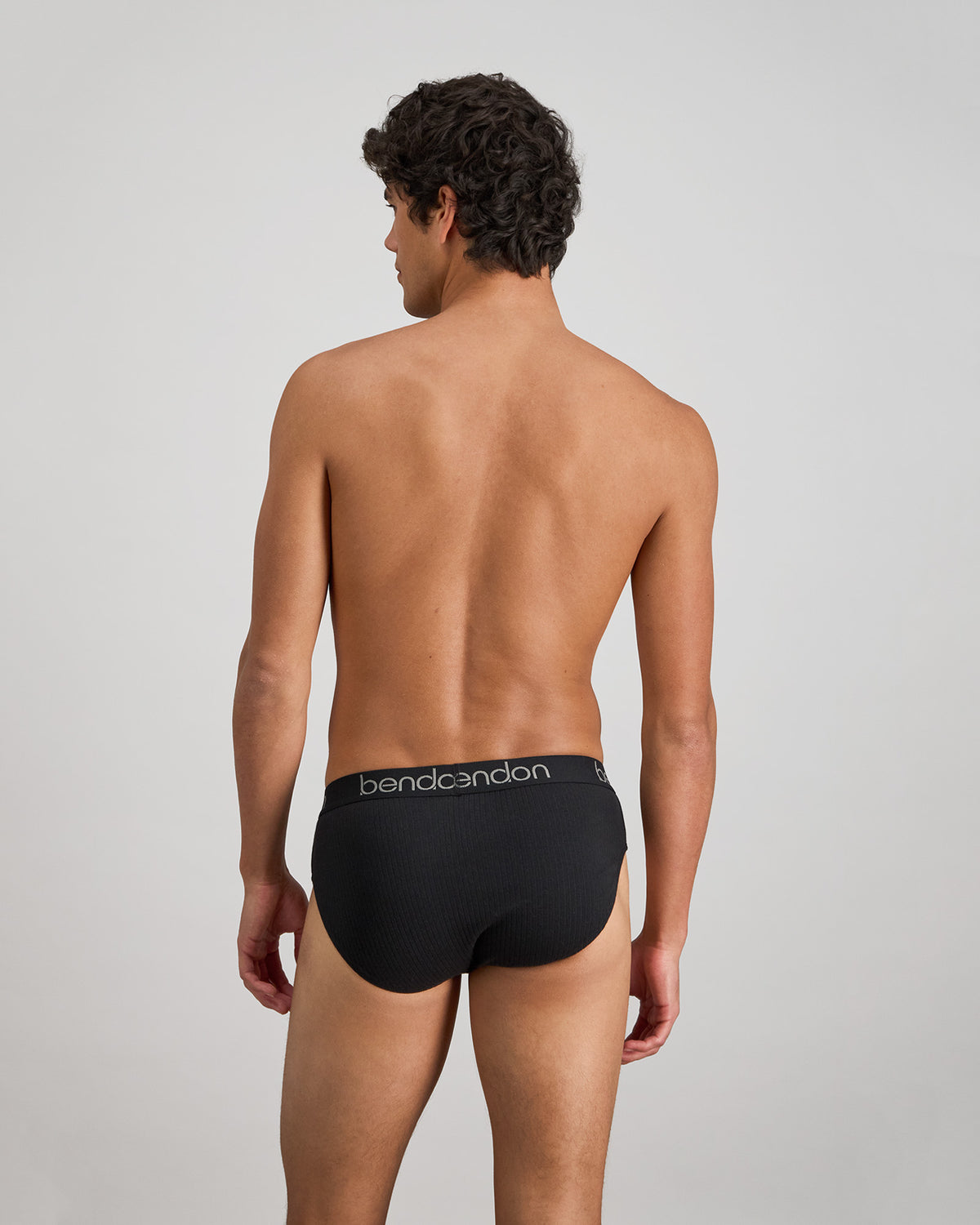 Model wears Cotton Texture Mens Brief in BLACK. On body back view