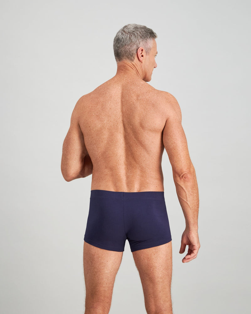 Model wears High Tech Cotton Mens Trunk in PEACOAT. On body back view