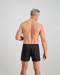 Model wears Cotton Basics Mens Trunk in BLACK. On body back view