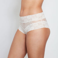 Model wears Lace Full Brief in WHITE. On body front view