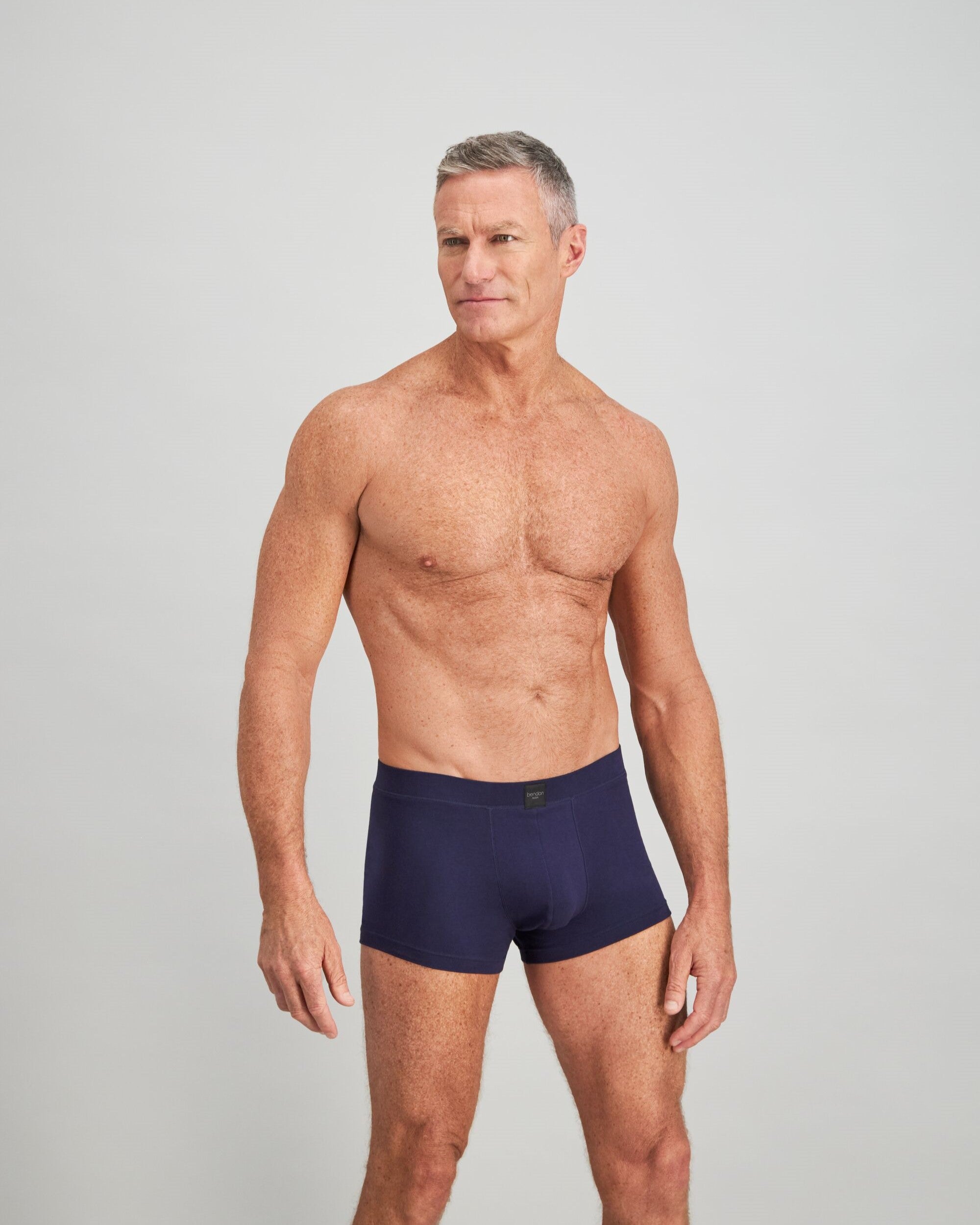 Model wears High Tech Cotton Mens Trunk in PEACOAT. On body side view