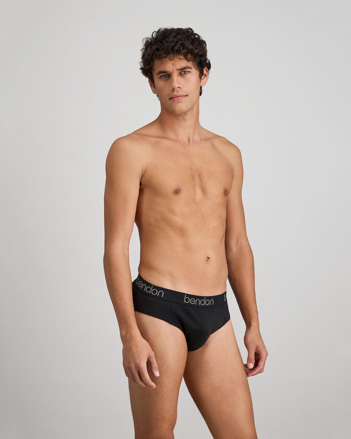 Model wears Cotton Texture Mens Brief in BLACK. On body side view