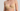 Beige strapless bra worn by a person on a plain background