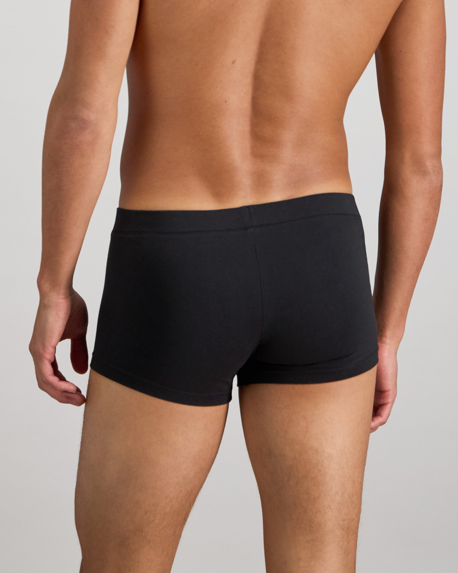 Model wears High Tech Cotton Mens Trunk in BLACK. On body back view