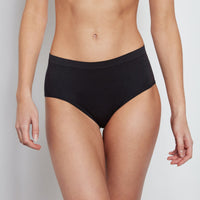 Model wears Seamless Full Brief in BLACK. On body front view