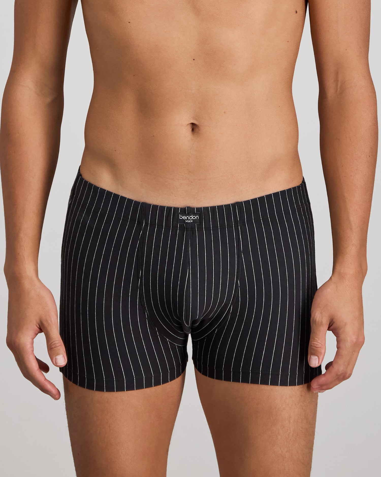 Model wears Cotton Stretch Mens Trunk in BLACK PINSTRIPE. On body front view