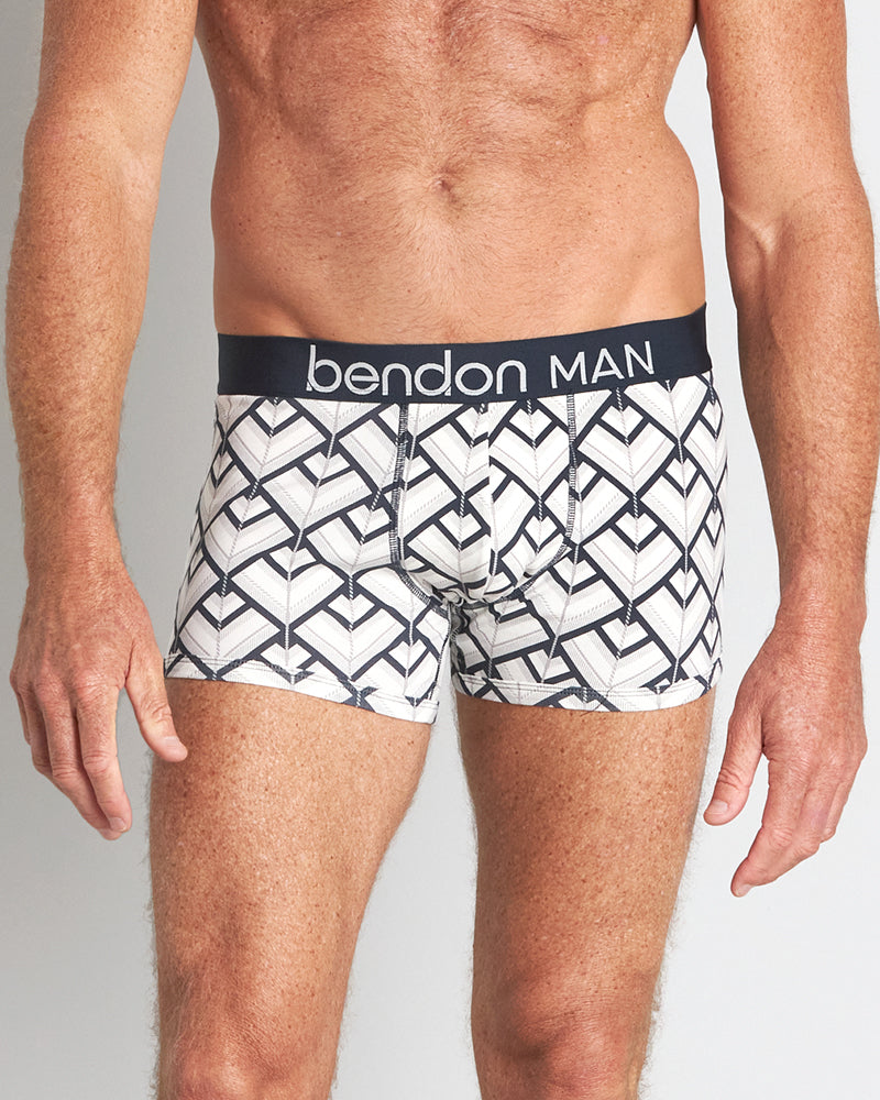 Model wears Retros Print Mens Trunk in ART DECO TILE PRINT. On body front view