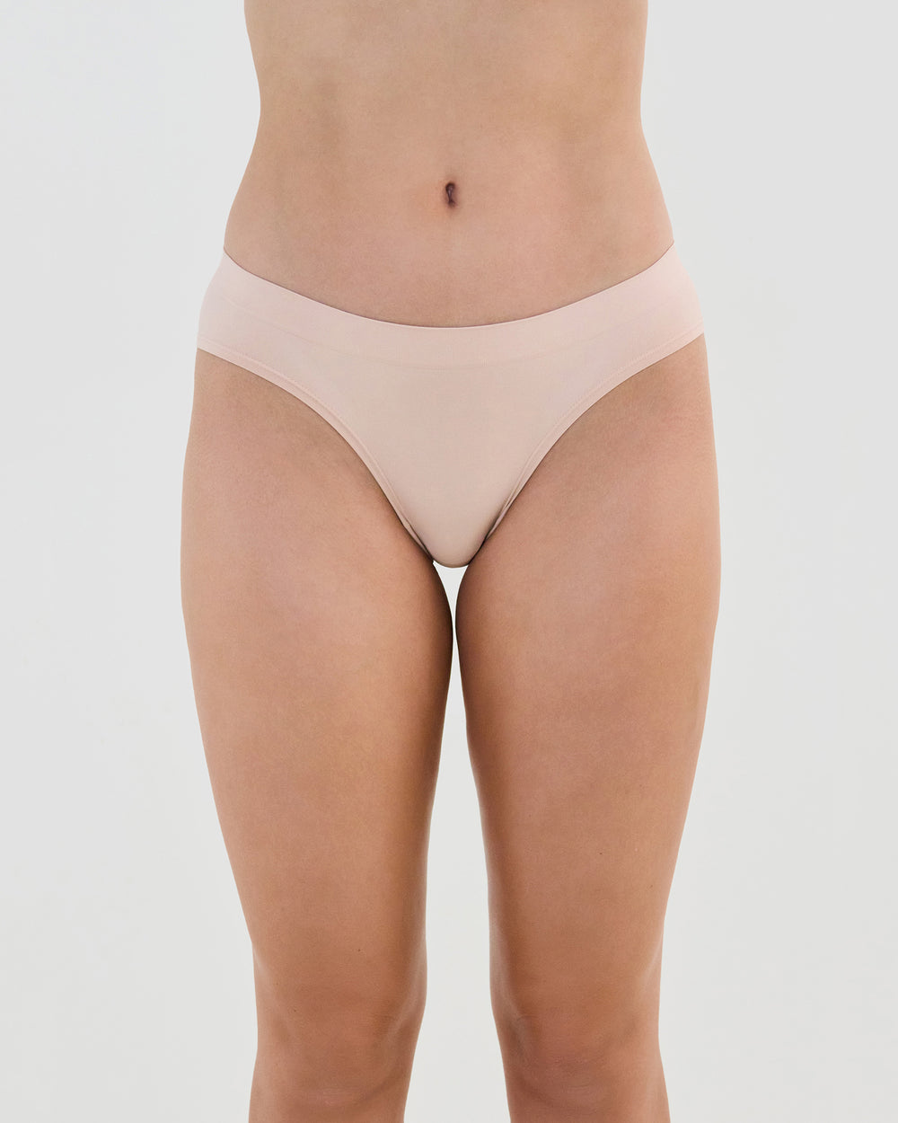 Model wears Seamless Soft Bikini in LATTE. On body front view