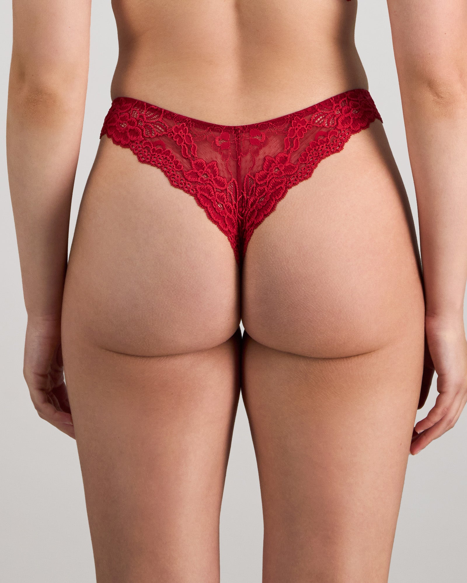 Model wears My Fit Lace Thong in JESTER RED. On body back view