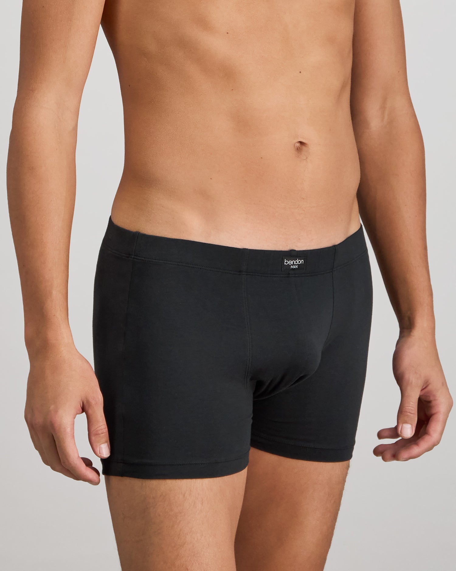 Model wears Cotton Stretch Mens Trunk in BLACK. On body side view