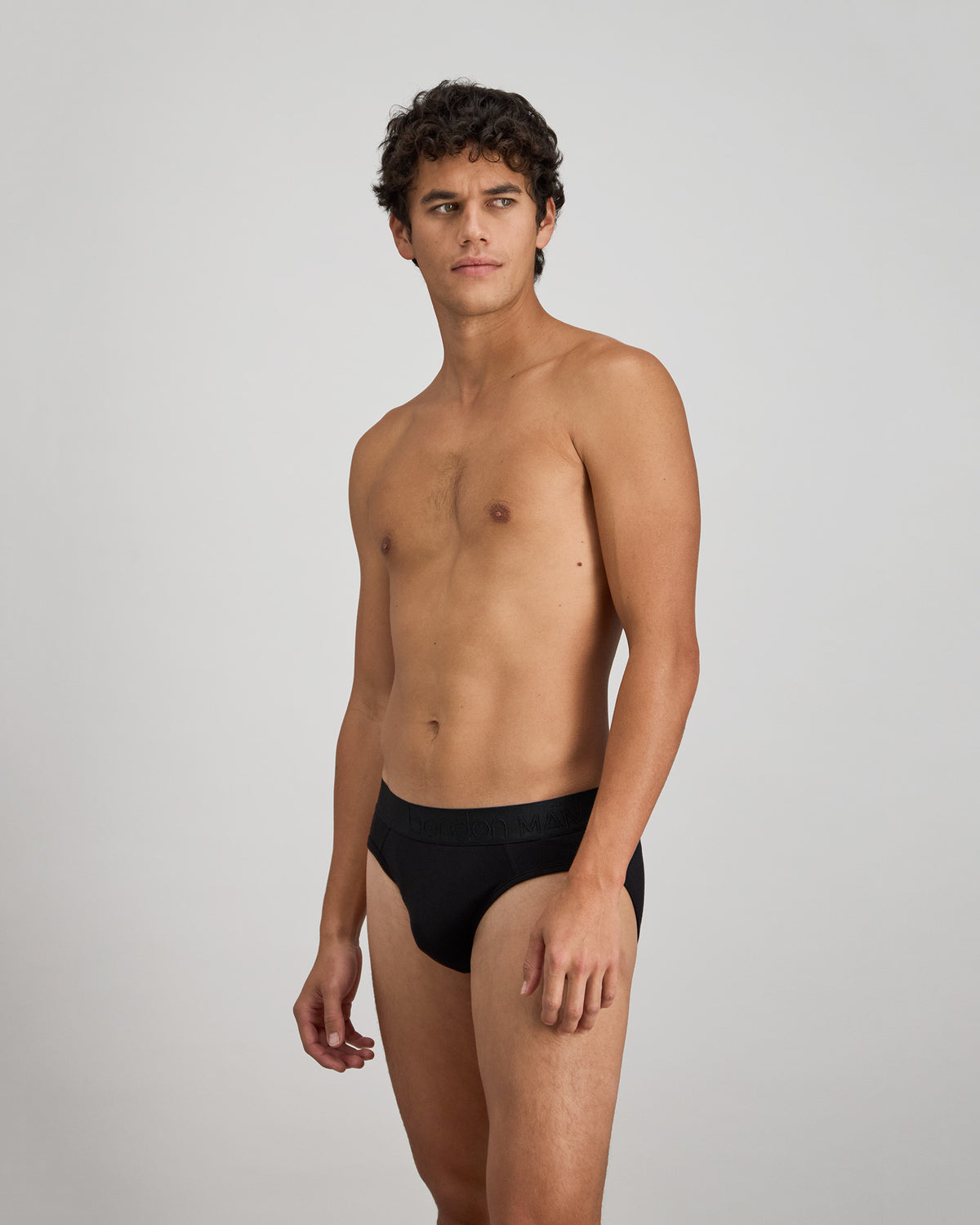Model wears Bamboo Mens Brief in BLACK. On body side view