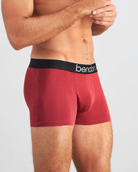 Model wears Everyday Essential Mens Trunk in TIBETAN RED. On body side view