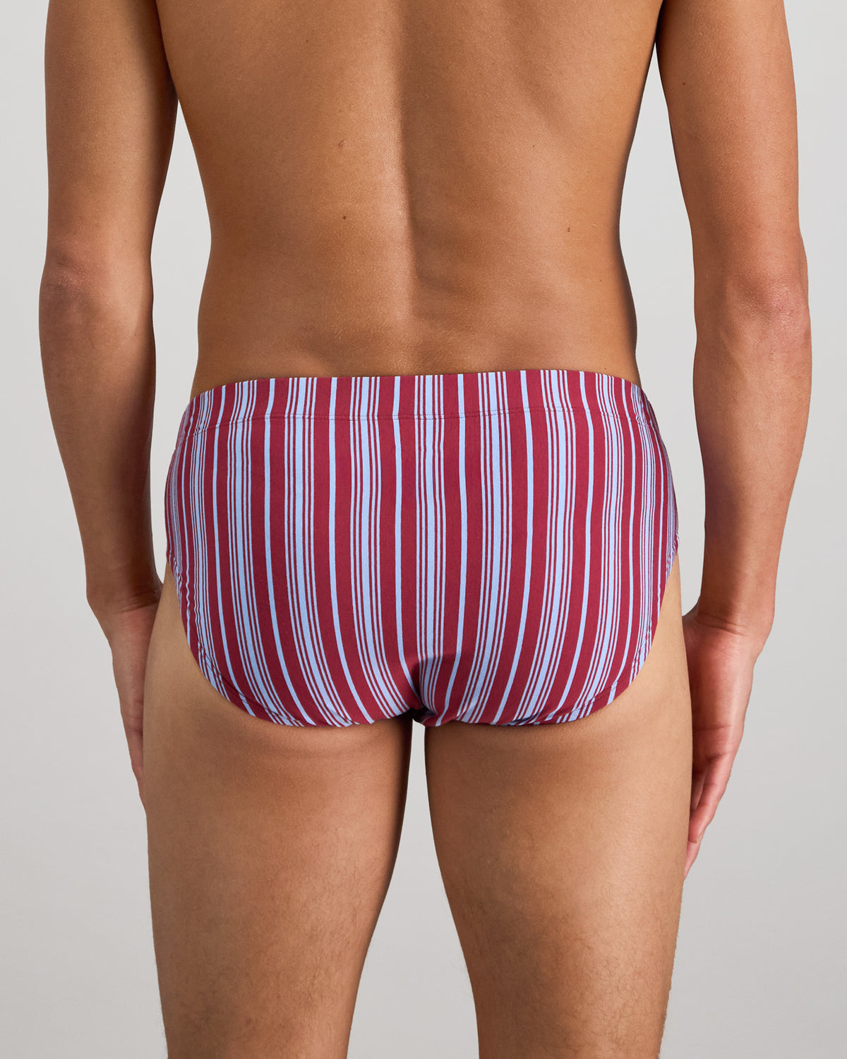 Model wears Cotton Stretch Mens Brief in TIBETAN RED STRIPE. On body back view