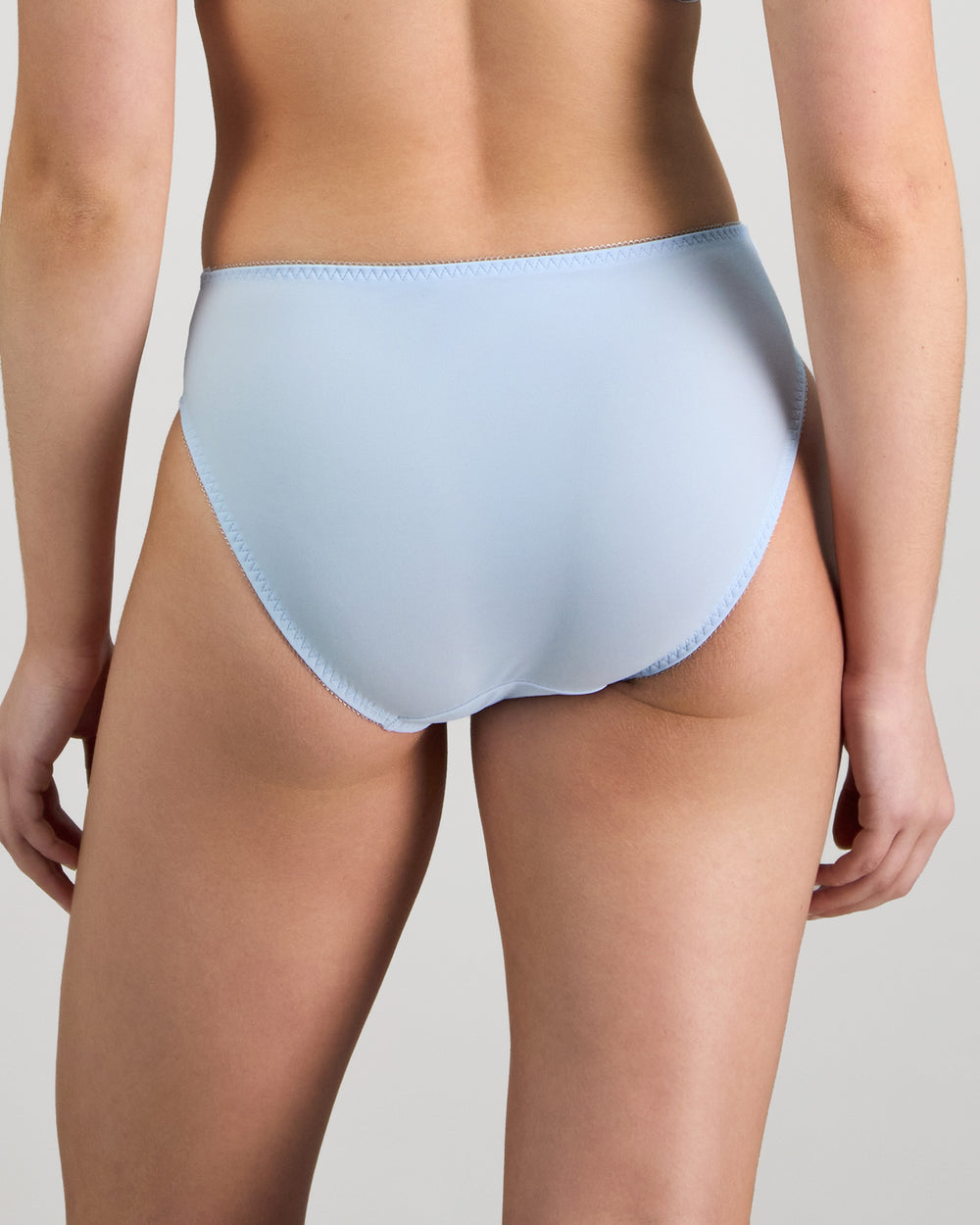 Model wears Coral High Cut Brief in SKYWAY. On body back view