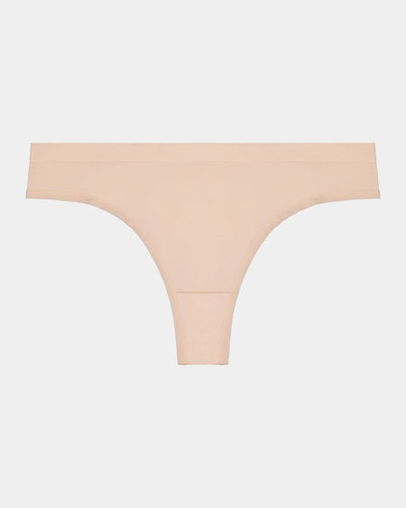 Model wears Seamless Thong in LATTE. On body front view