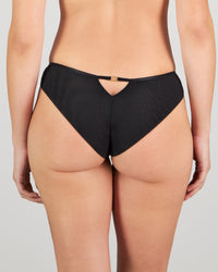 Model wears Sheer Impact Brazilian in BLACK. On body back view