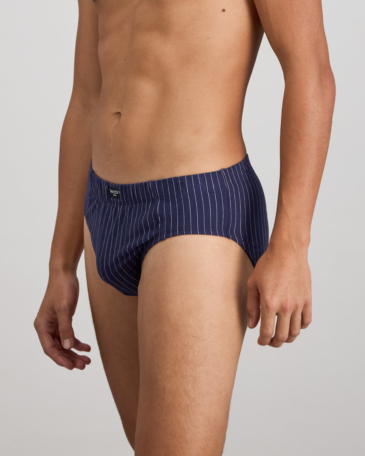 Model wears Cotton Stretch Mens Brief in PEACOAT PINSTRIPE. On body side view