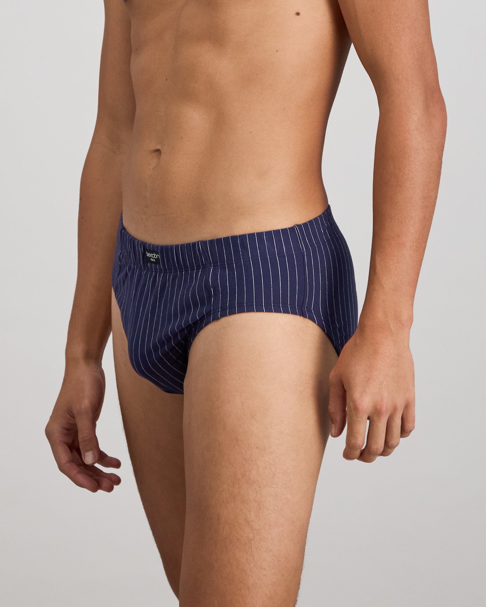 Model wears Cotton Stretch Mens Brief in PEACOAT PINSTRIPE. On body side view
