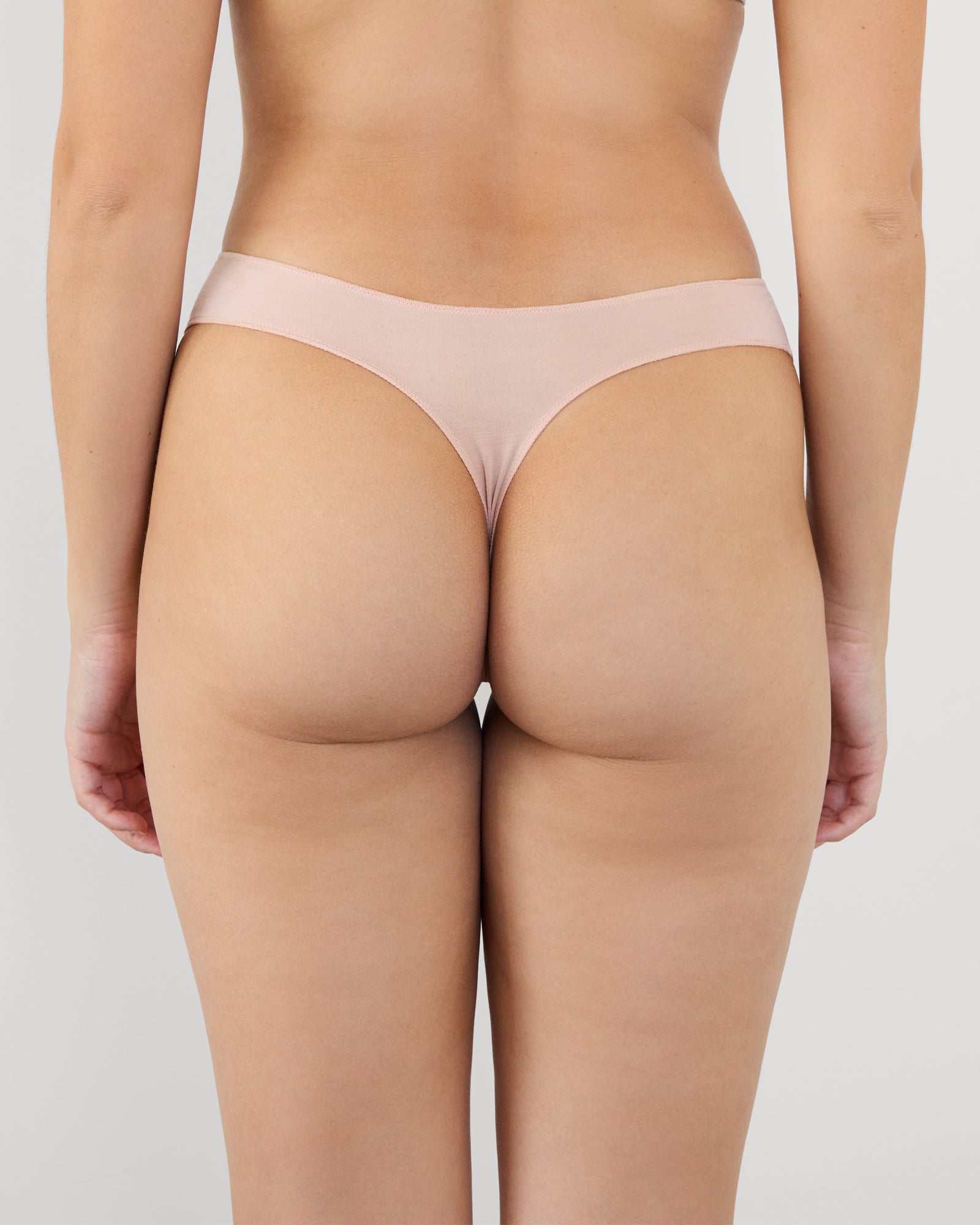 Model wears Au Naturel Thong in LATTE. On body back view