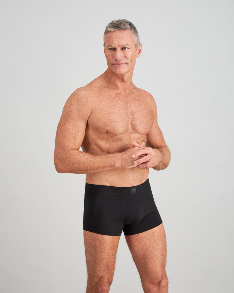 Model wears High Tech Cotton Mens Trunk in BLACK. On body side view
