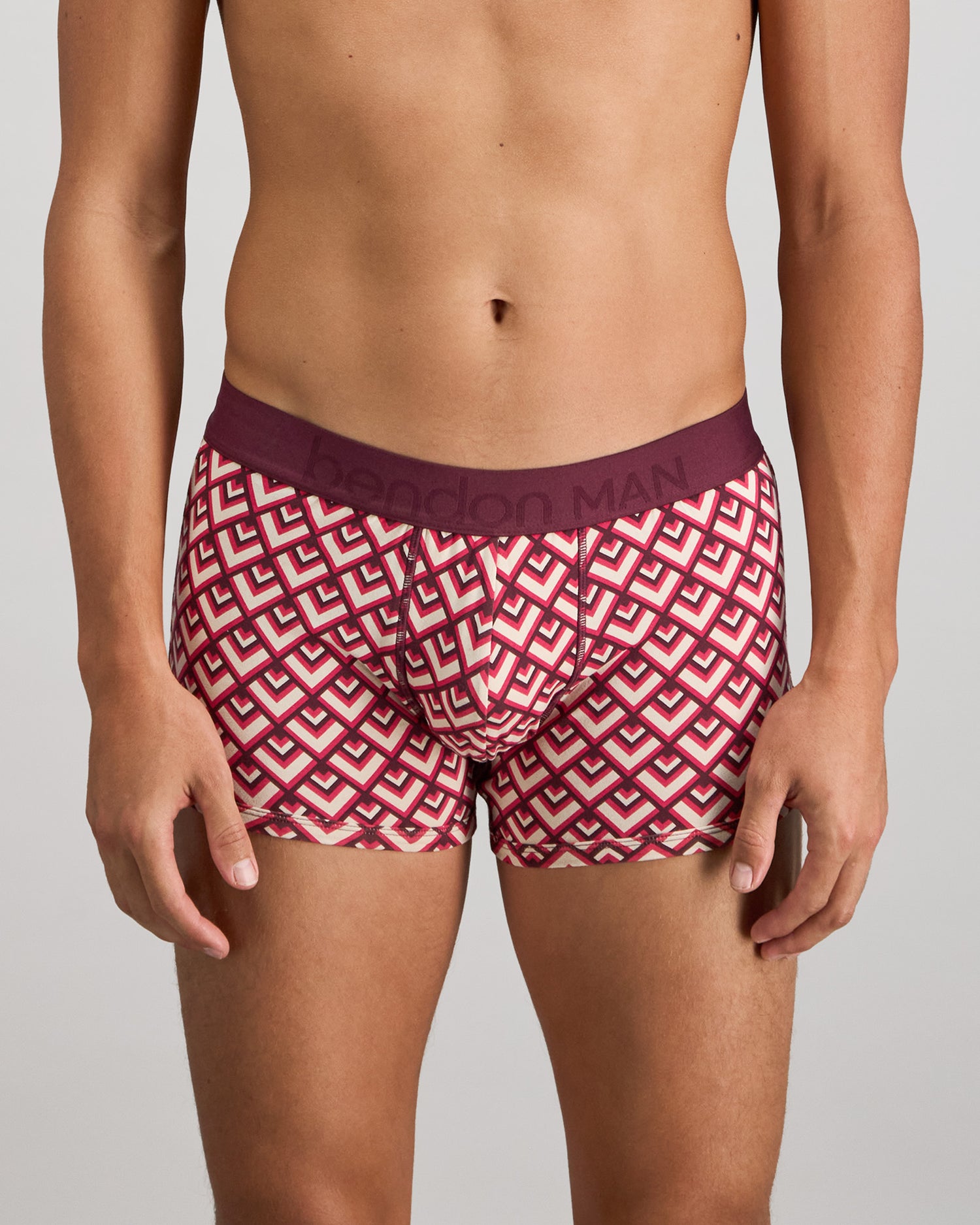 Model wears Retros Print Mens Trunk in ART TILE PRINT. On body front view