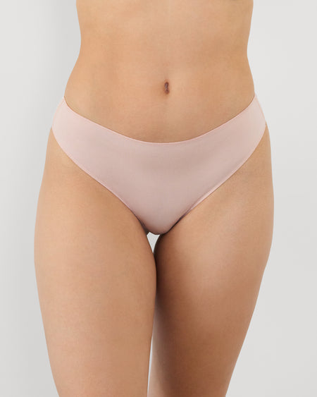 Model wears Au Naturel Thong in LATTE. On body front view