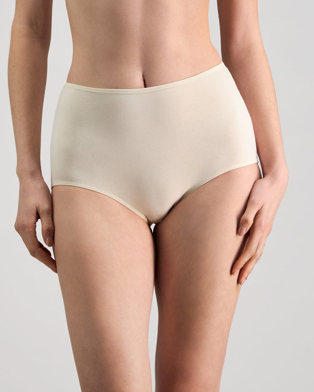 Model wears Freestyle Full Brief in CHAMPAGNE. On body front view