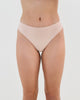 Model wears Seamless Soft Thong in LATTE. On body front view