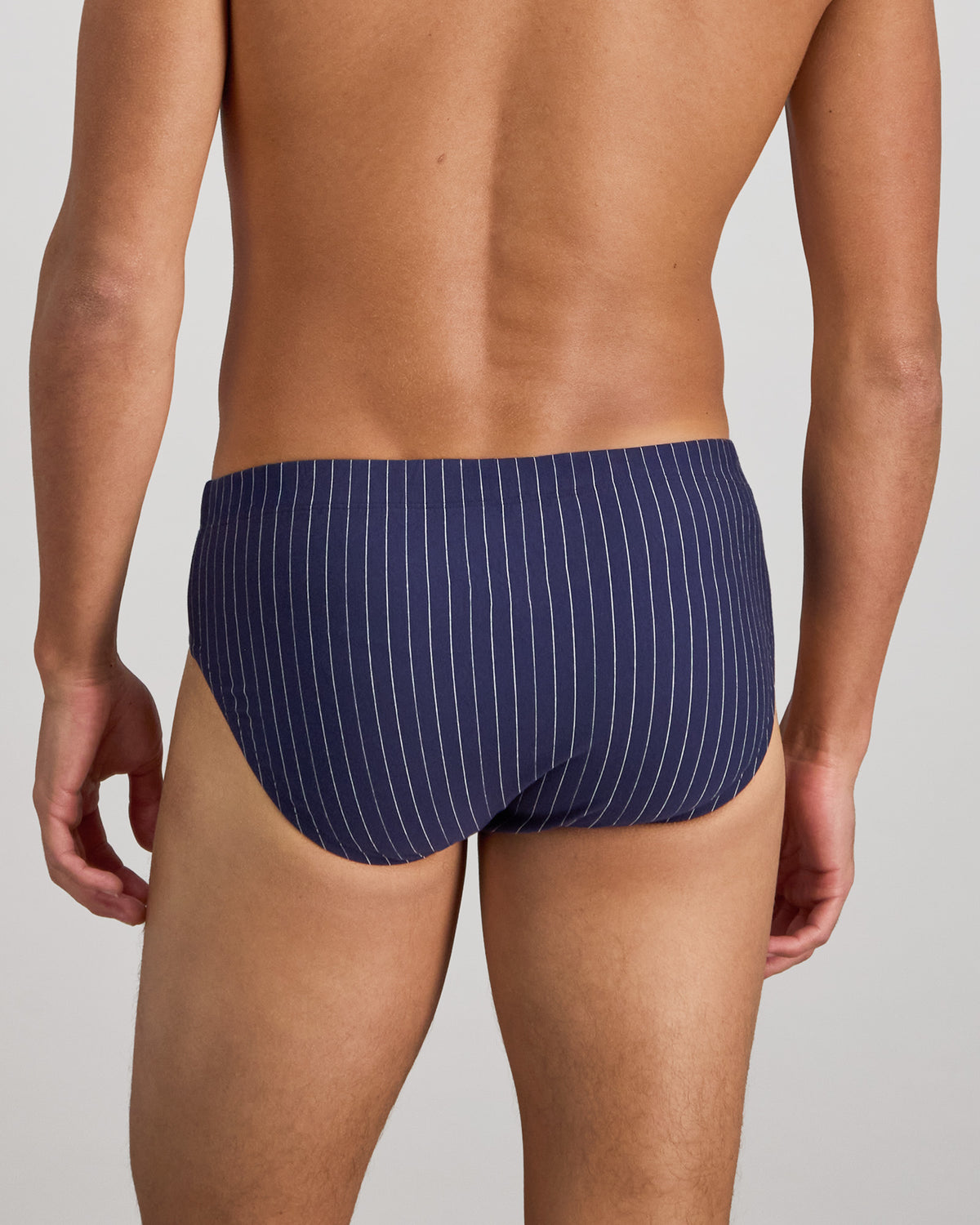 Model wears Cotton Stretch Mens Brief in PEACOAT PINSTRIPE. On body back view