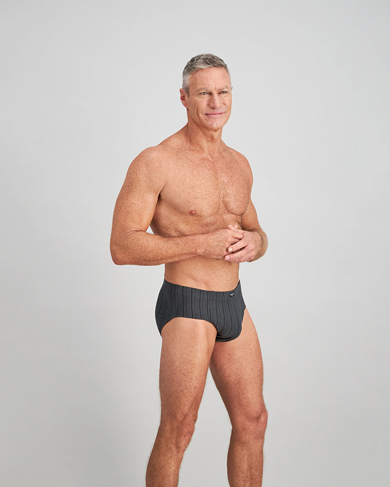Model wears Cotton Stretch Mens Brief in CHAR BLACK. On body side view