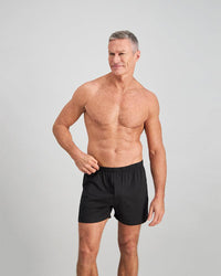 Model wears Cotton Basics Mens Trunk in BLACK. On body front view