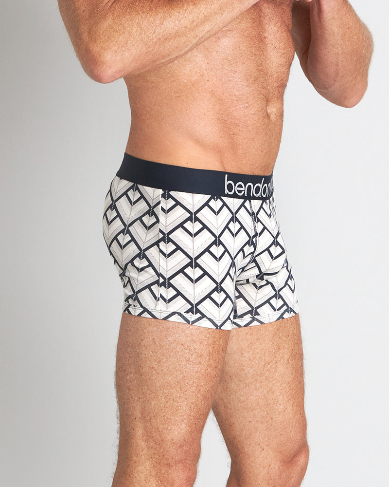 Model wears Retros Print Mens Trunk in ART DECO TILE PRINT. On body side view