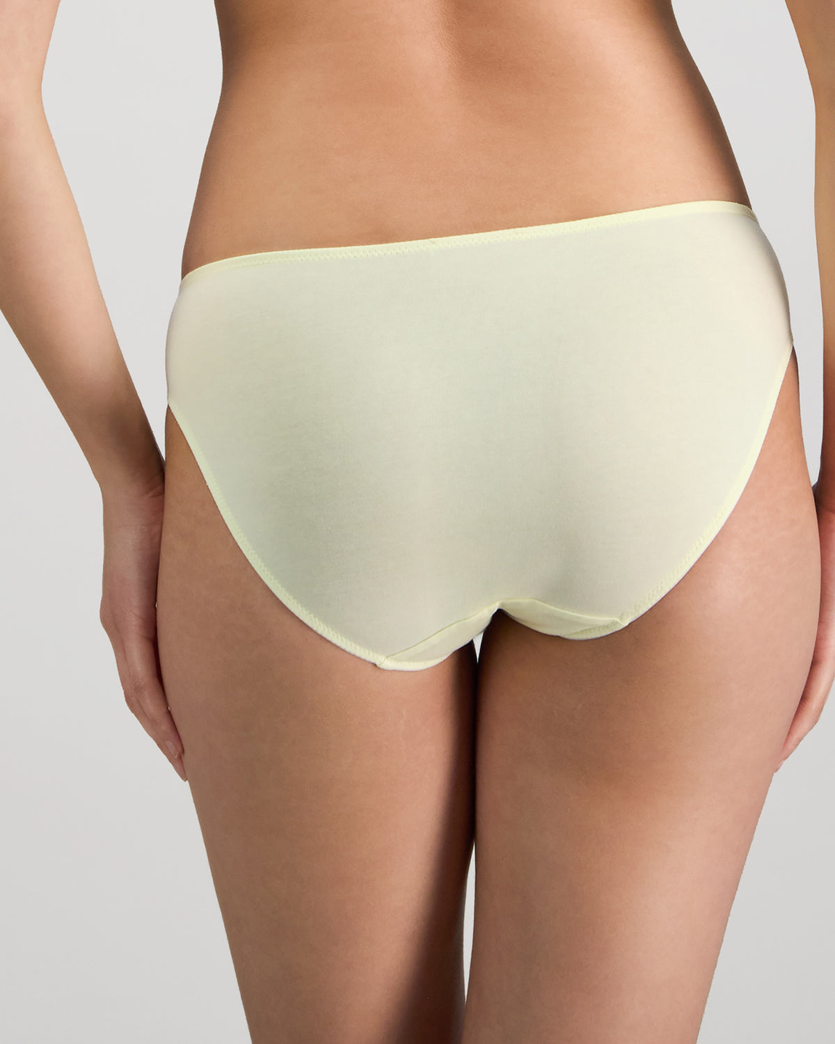 Model wears Embrace Bikini in TRANSPARENT YELLOW. On body back view
