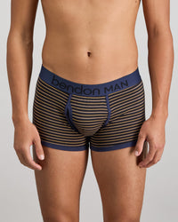 Model wears Bold Stripe Mens Trunk in BLACK/OAK BUFF STRIPE. On body front view