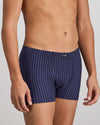 Model wears Cotton Stretch Mens Trunk in PEACOAT PINSTRIPE. On body side view