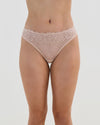 Model wears All Lacey Thong in LATTE. On body front view
