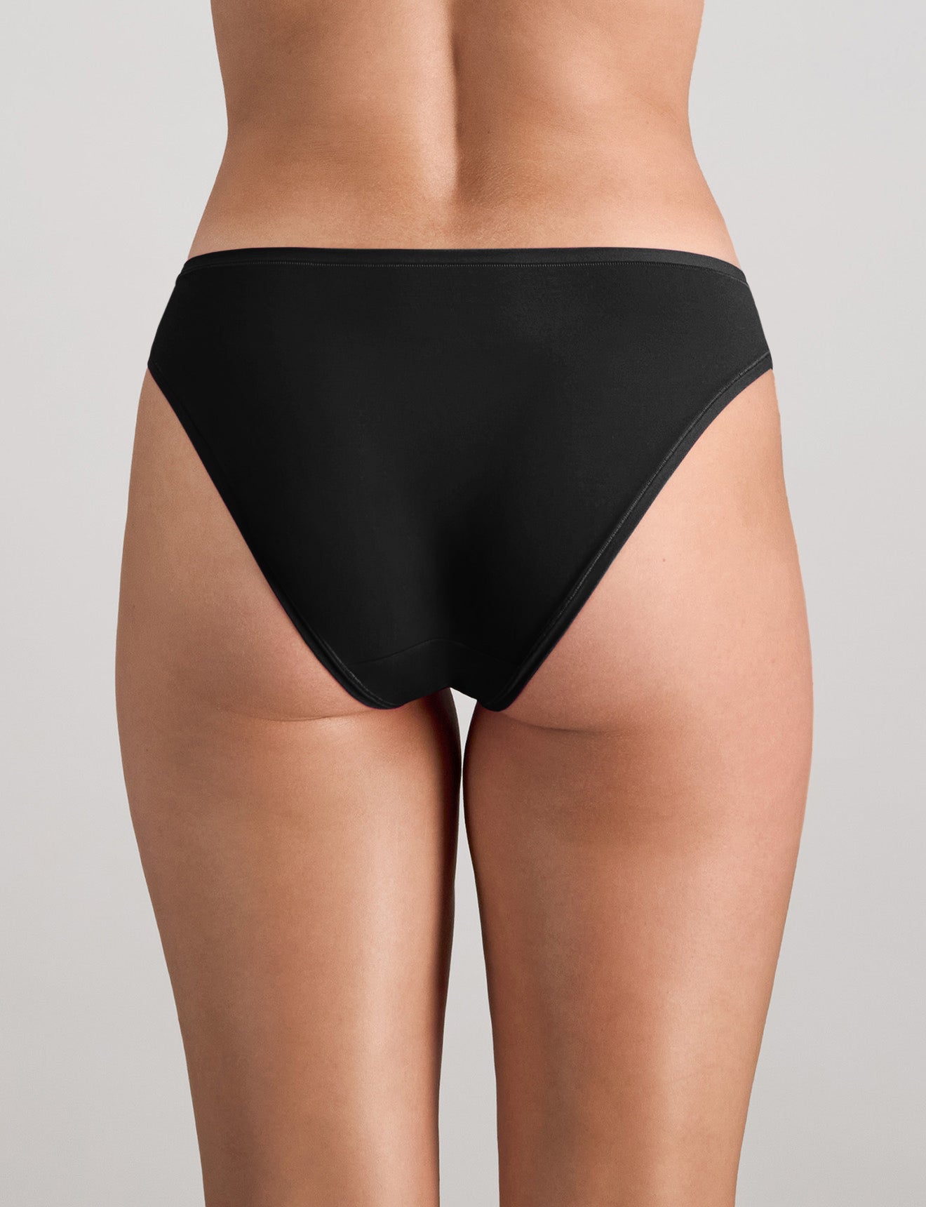 Model wears Extra-Ordinary Bikini Brief in BLACK. On body back view