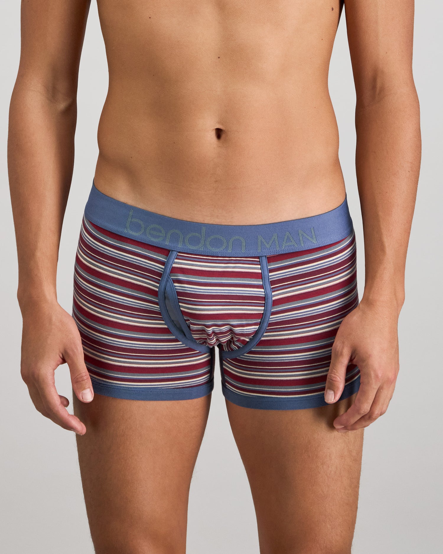 Model wears Bold Stripe Mens Trunk in INDIGO/FIG STRIPE. On body front view