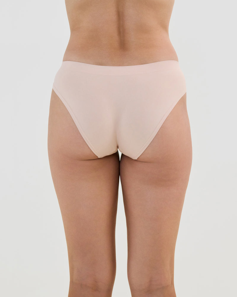 Model wears Seamless Soft Bikini in LATTE. On body back view