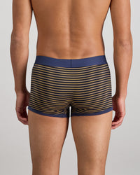 Model wears Bold Stripe Mens Trunk in BLACK/OAK BUFF STRIPE. On body back view