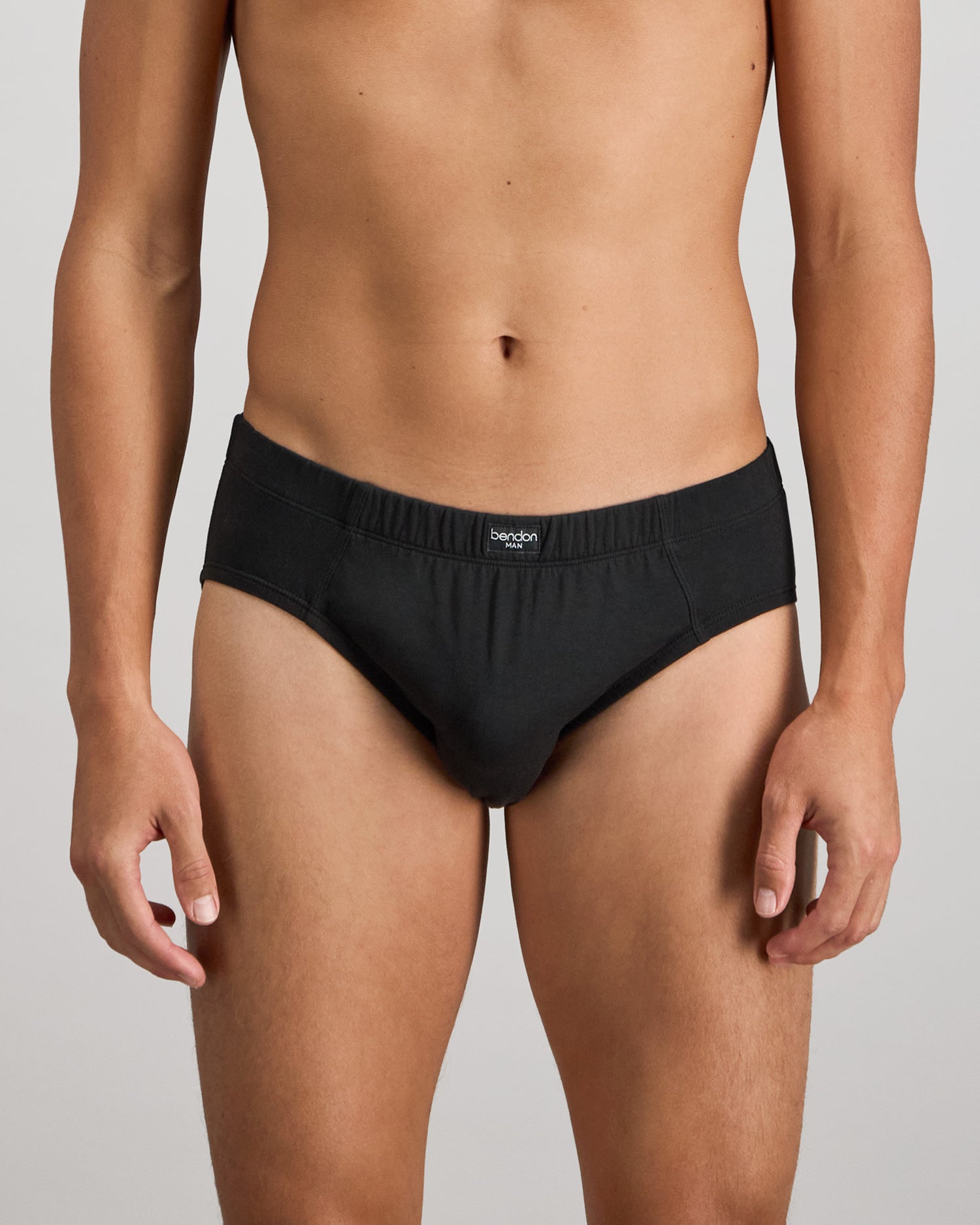 Model wears Cotton Stretch Mens Brief in BLACK. On body front view